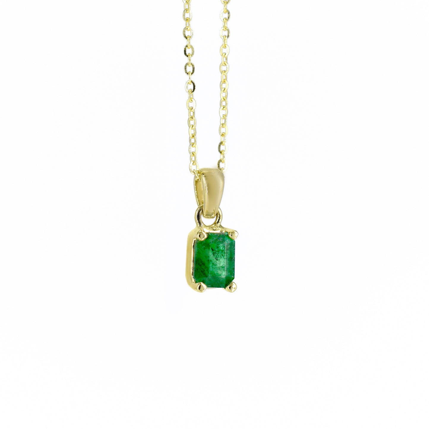 Collar de oro amarillo con un dije rectangular que engasta una esmeralda natural de color verde intenso, suspendido de una cadena de eslabones finos, sobre un fondo blanco.