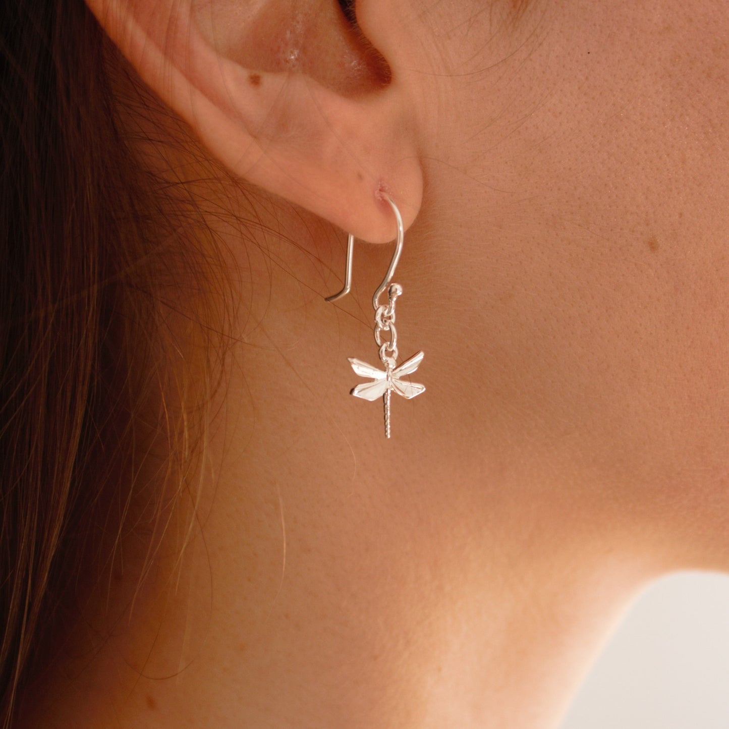 Aretes colgantes libelula origami plata en uso