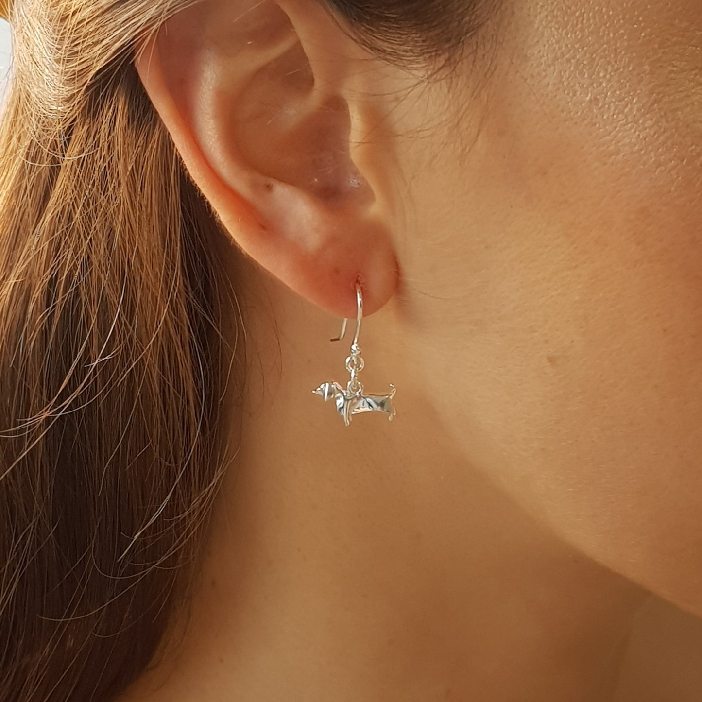 Aretes de Perro Salchicha origami plata .925 en uso.