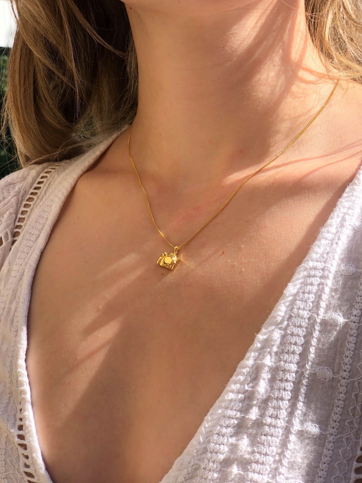 COLLAR CAMARA DSLR DE BAÑO DE ORO EN MODELO.