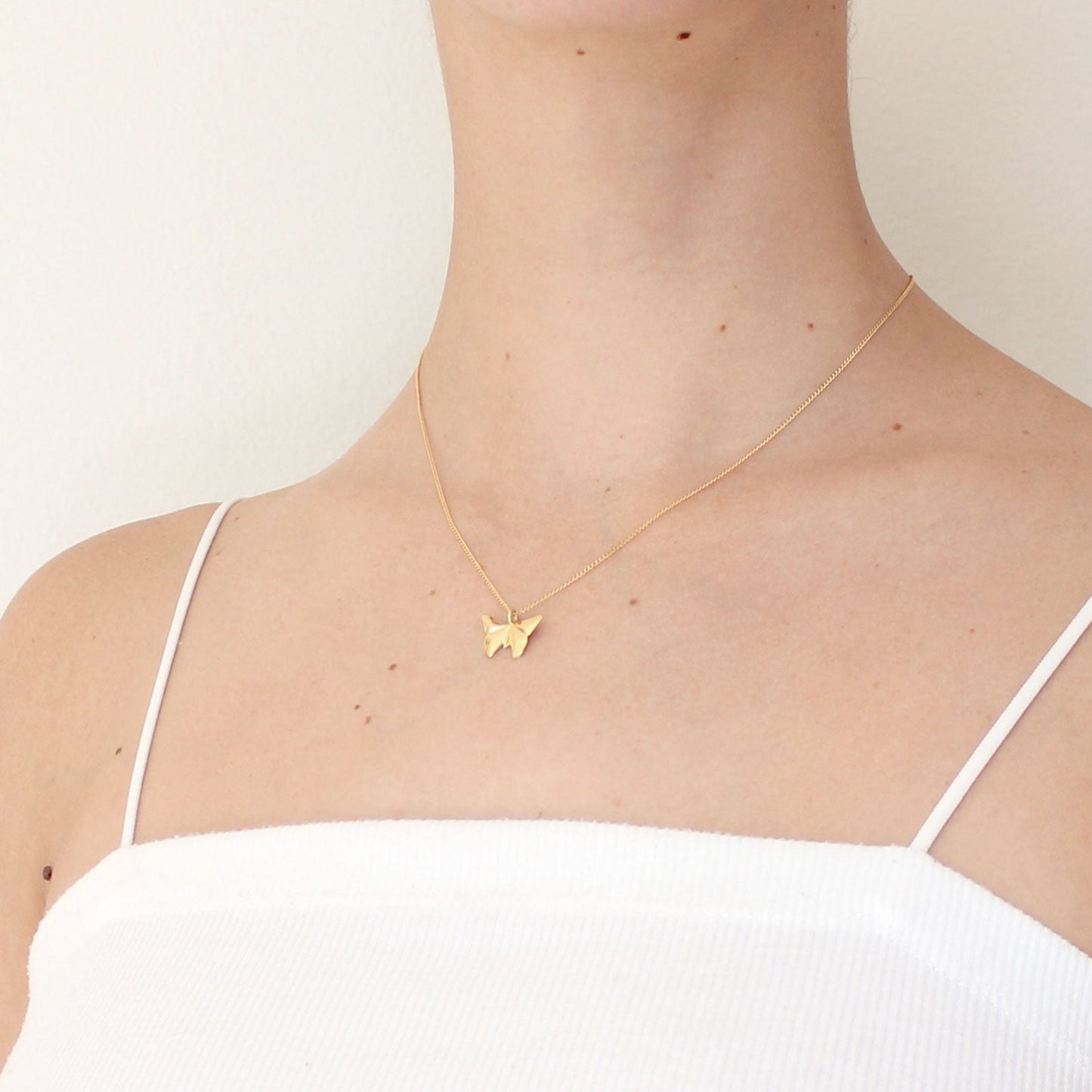 collar mariposa dorado en modelo