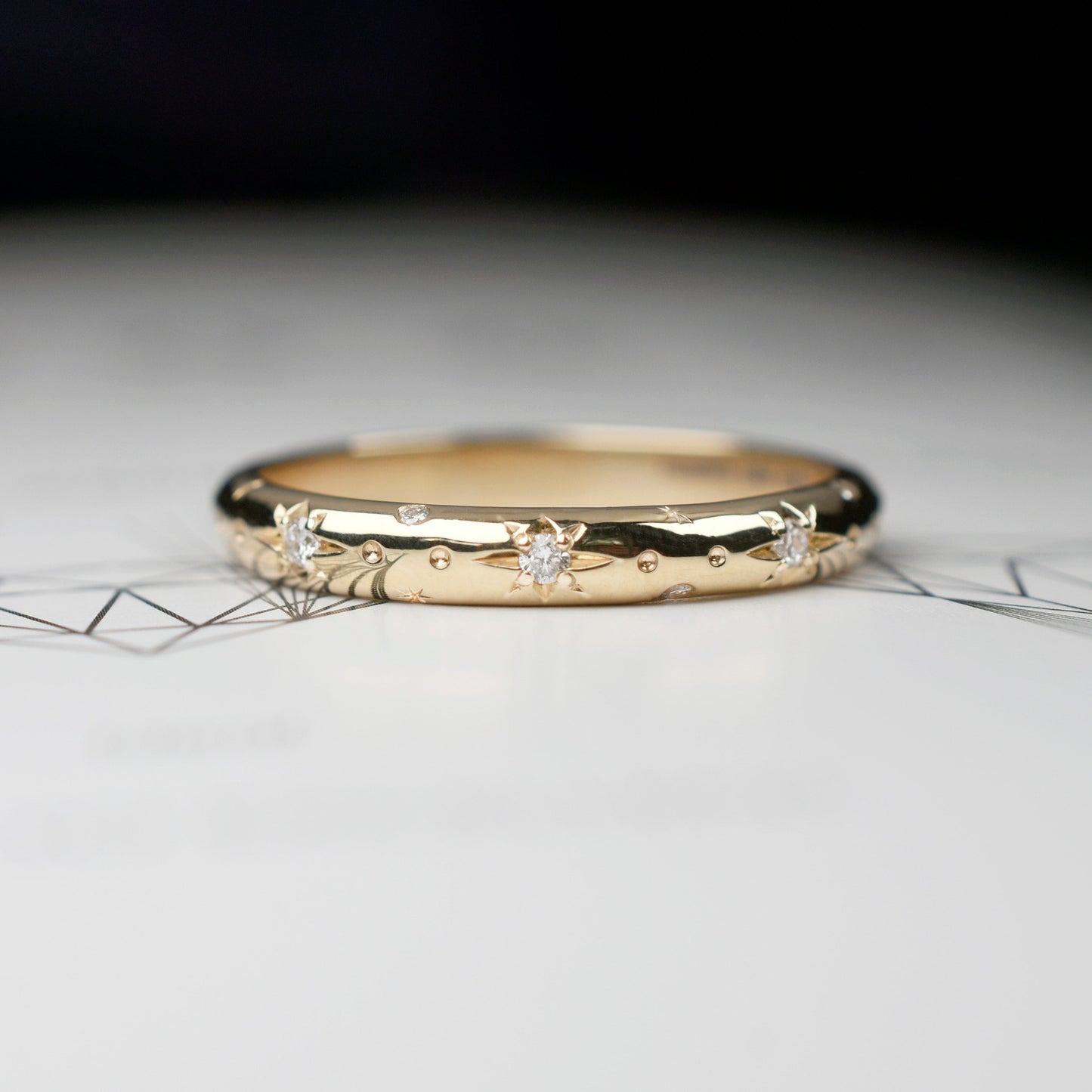 Alianza de matrimonio en oro amarillo pulido con estrellas grabadas y diamantes, argolla fina de estilo celestial para novia.