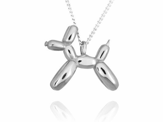 Collar de plata con un dije de perrito de globo brillante, mostrando su forma de animal inflado y enredado, sobre un fondo blanco con un sutil reflejo en la parte inferior.