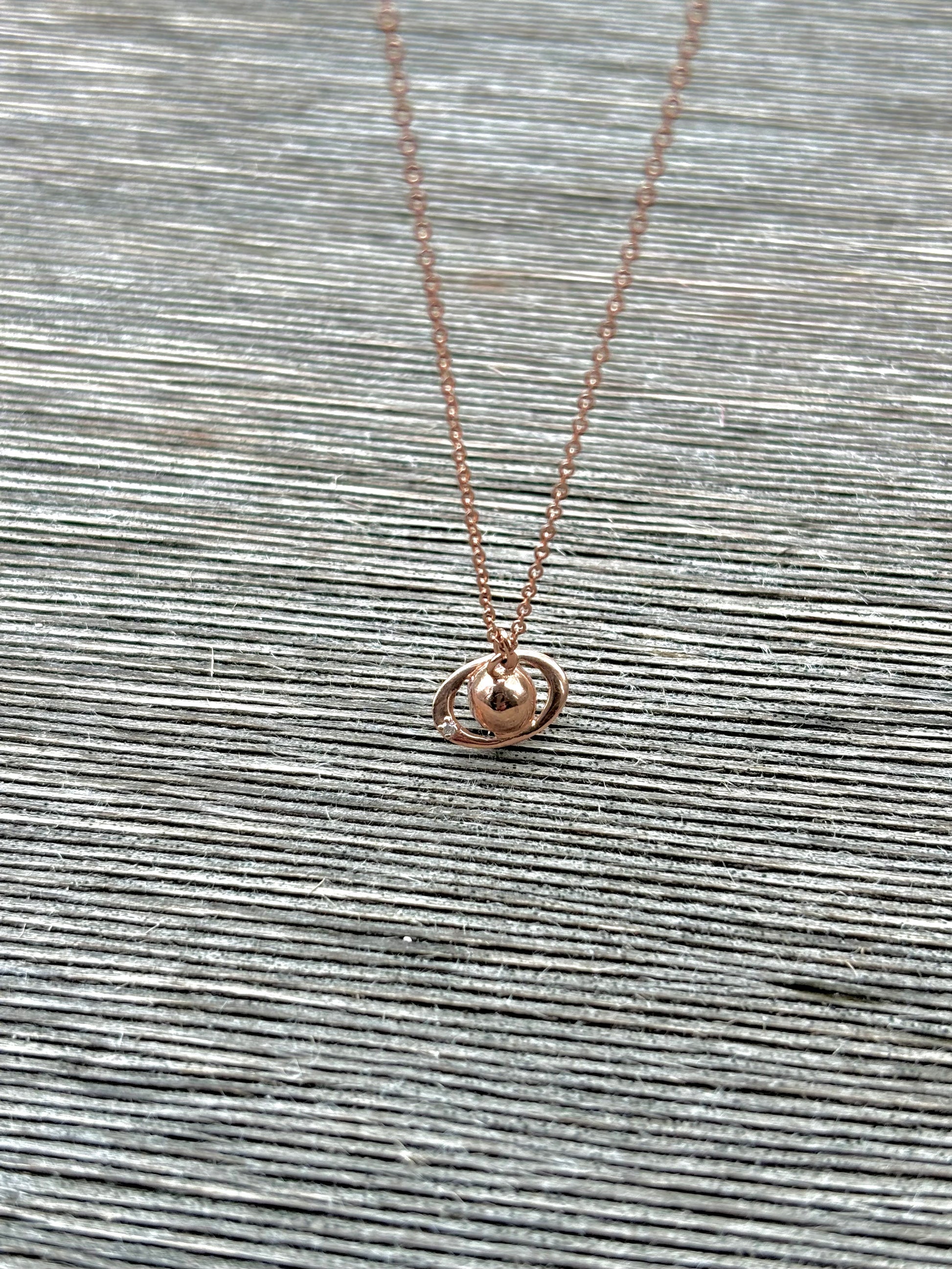 foto collar Saturno en chapa de Oro Rosa.
