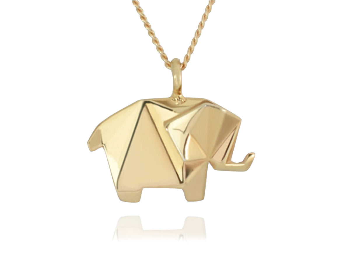 Collar de oro con un dije de elefante estilo origami, visto de frente con una ligera inclinación y un reflejo tenue debajo, sobre un fondo blanco.