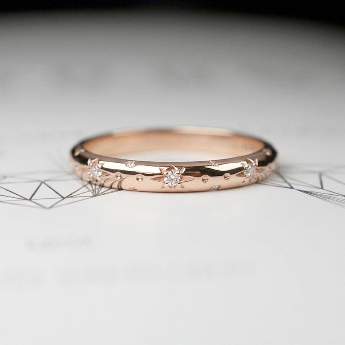 Alianza de matrimonio en oro rosa pulido con estrellas grabadas y diamantes, argolla fina de estilo celestial para novia.
