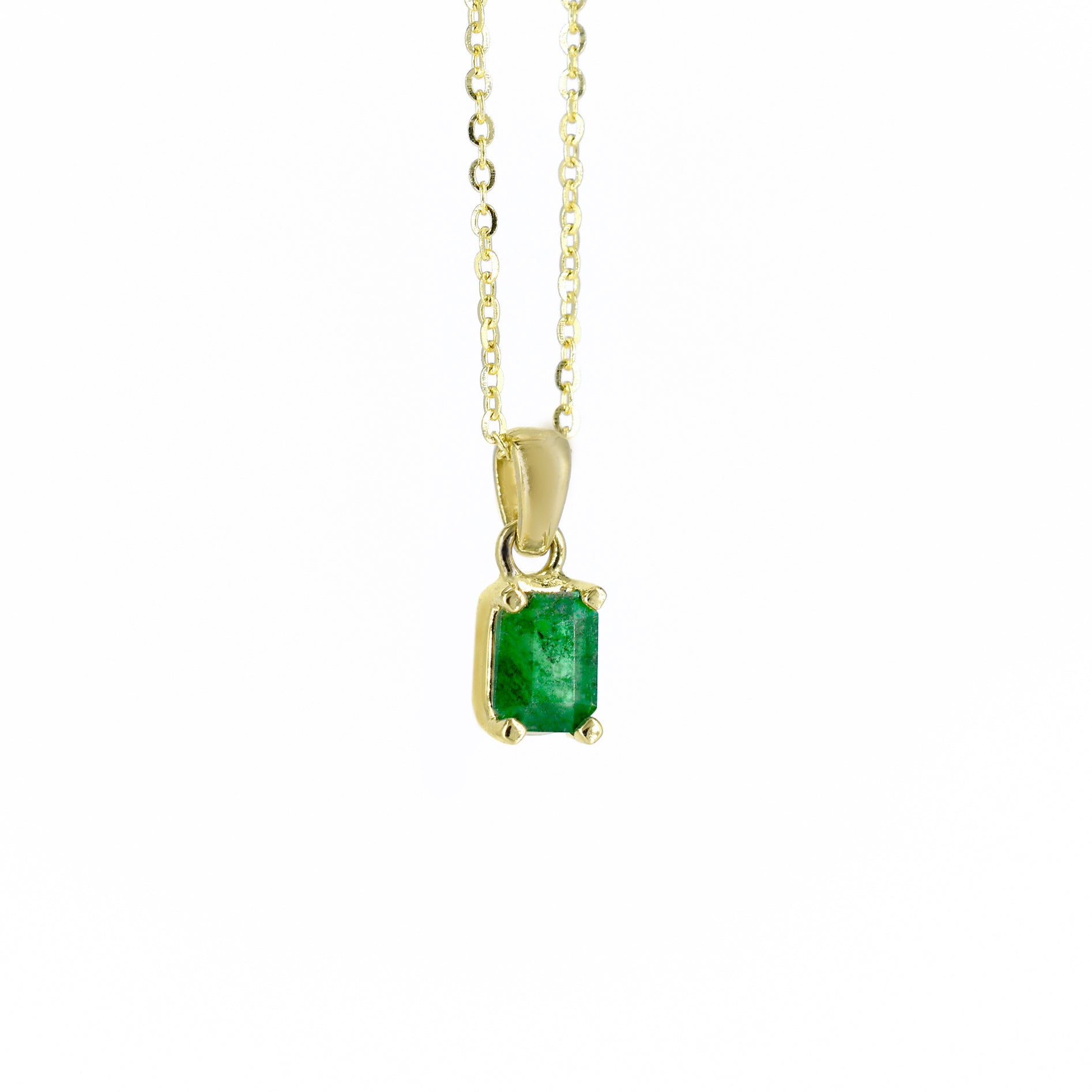 Collar de oro amarillo con un dije rectangular que engasta una esmeralda natural de color verde intenso, suspendido de una cadena de eslabones finos, sobre un fondo blanco.