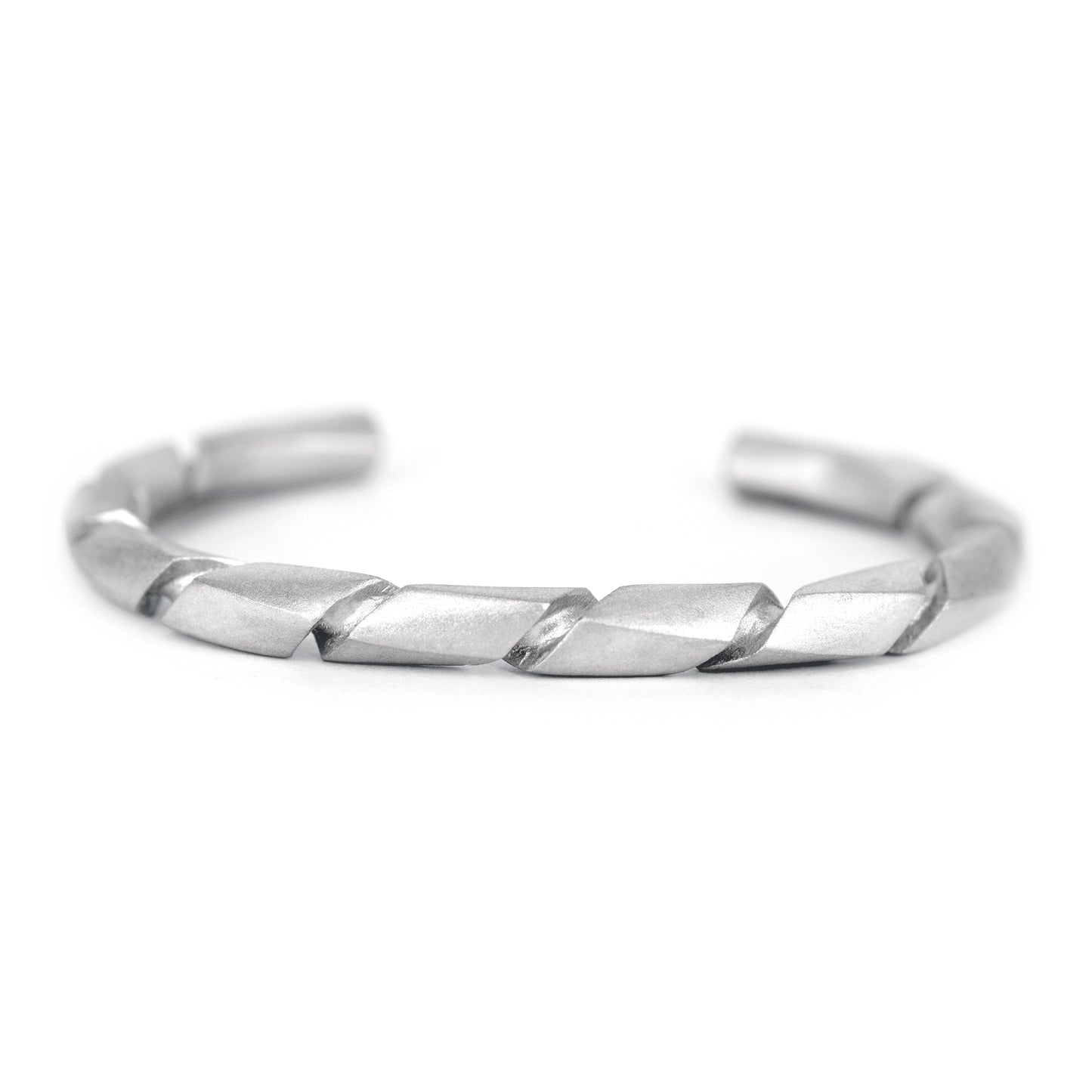 Pulsera de plata con acabado mate y un diseño torcido o en espiral, vista en primer plano.