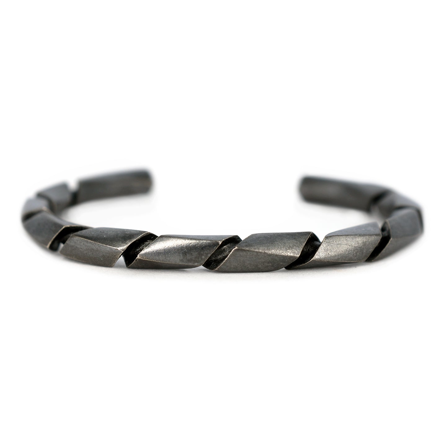 Pulsera de plata con acabado pavondado negro y un diseño torcido o en espiral, vista en primer plano.