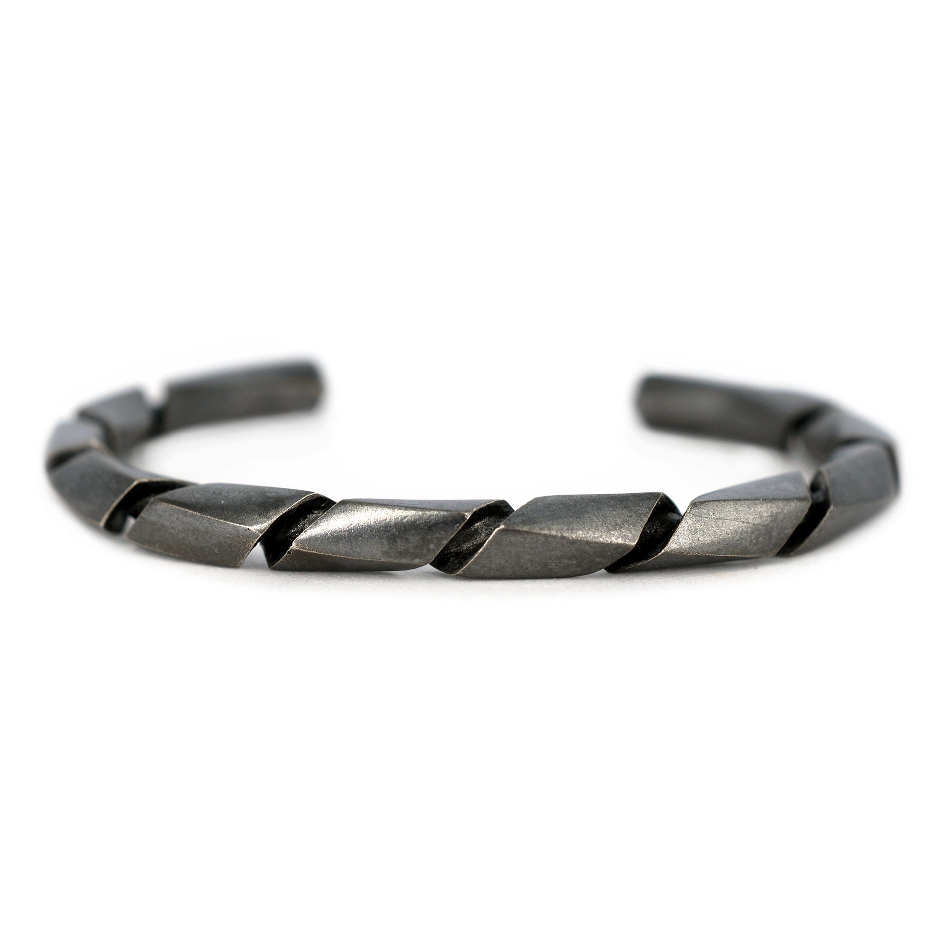 Pulsera de plata con acabado pavondado negro y un diseño torcido o en espiral, vista en primer plano.