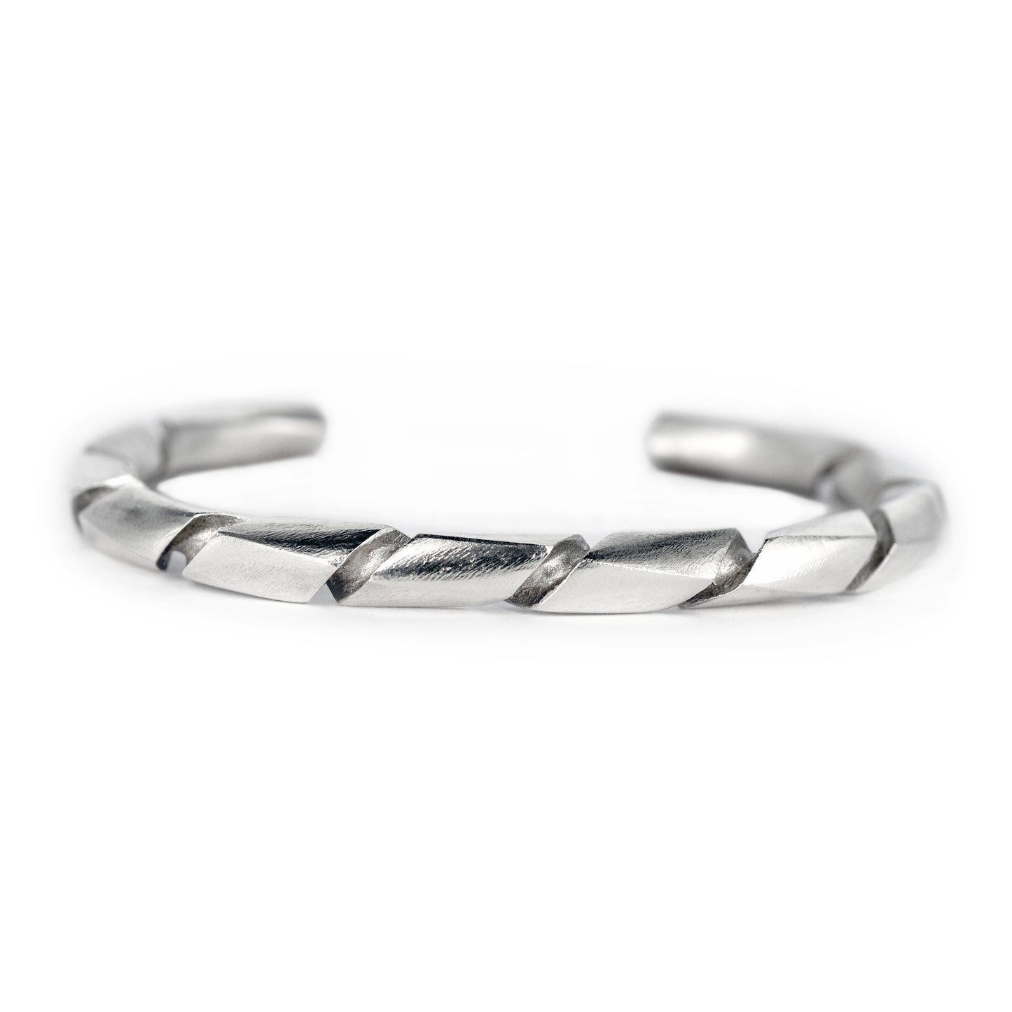 Pulsera de plata con acabado satín y un diseño torcido o en espiral, vista en primer plano.