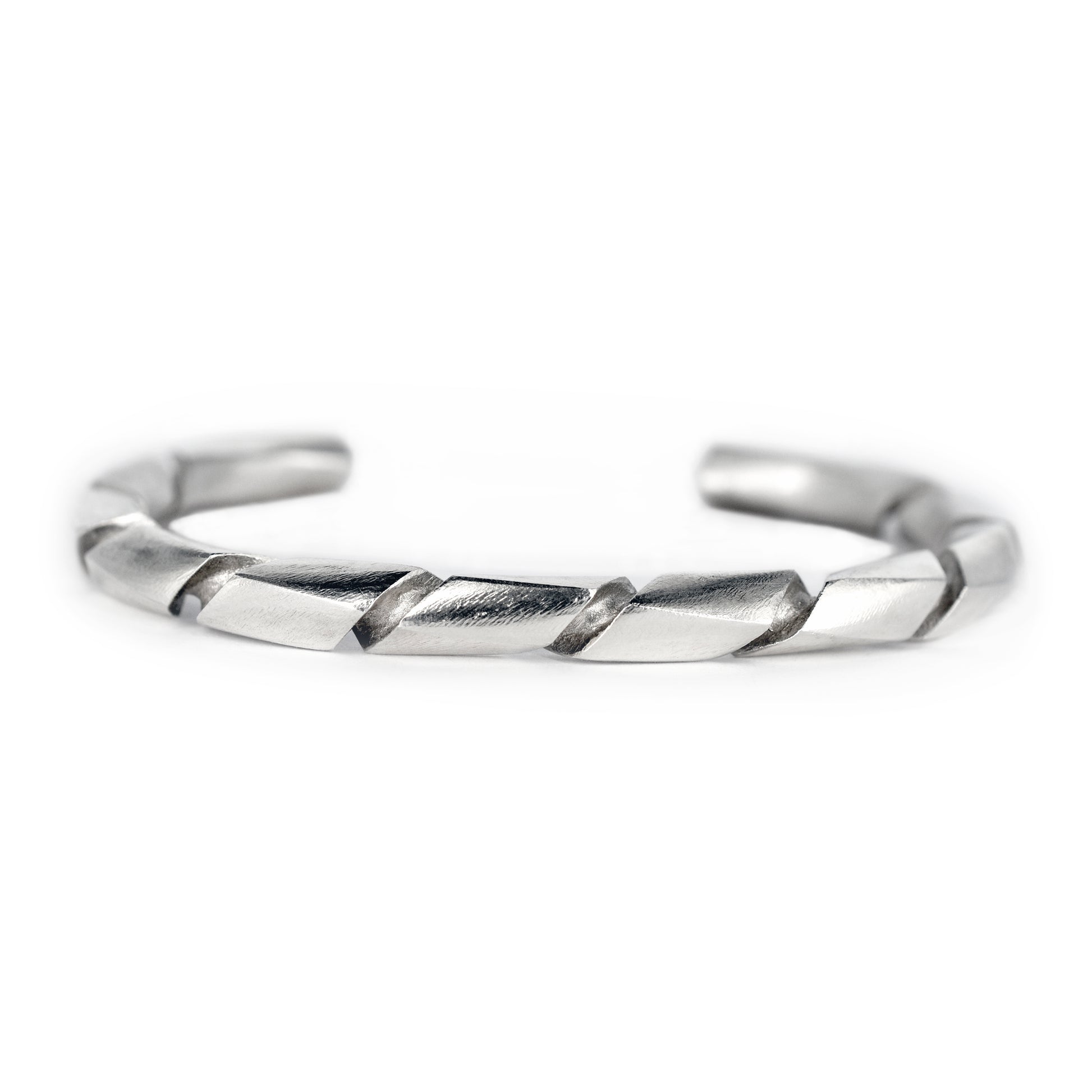 Pulsera de plata con acabado satín y un diseño torcido o en espiral, vista en primer plano.