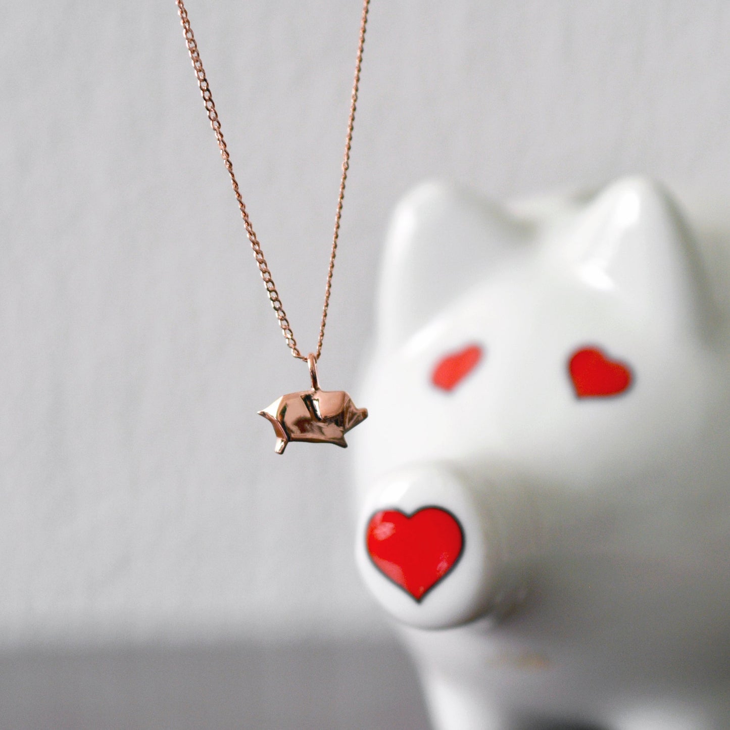 collar cerdito rosa con cerdito ce4ramica de fondo